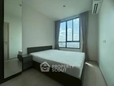 Spacious bedroom with large window offering stunning city views and ample natural light.