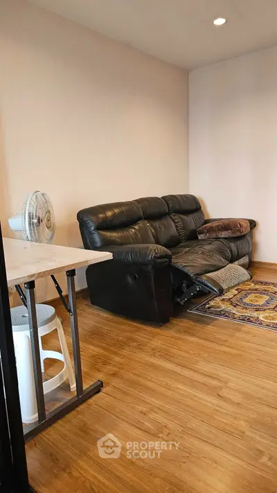Cozy living room with leather sofa and wooden flooring