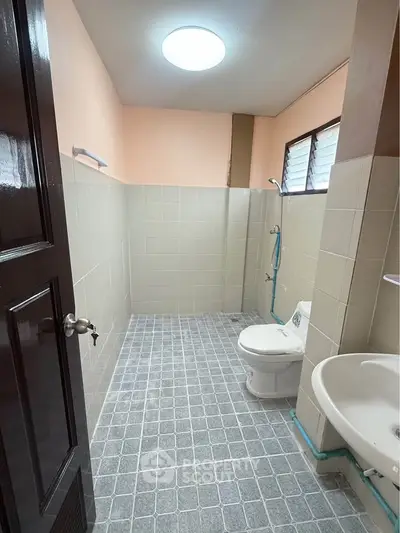 Spacious bathroom with modern fixtures and tiled flooring