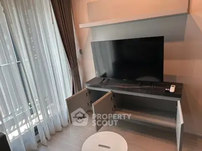 Modern living room with sleek TV stand and large window drapes