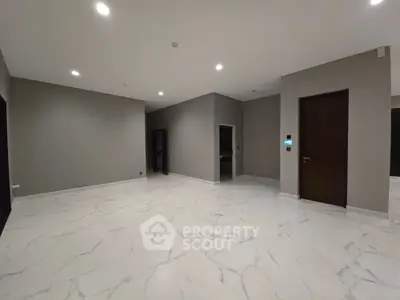Spacious modern interior with marble flooring and neutral walls, ideal for versatile living space.
