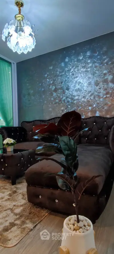 Luxurious living room with elegant chandelier and plush seating in modern apartment.
