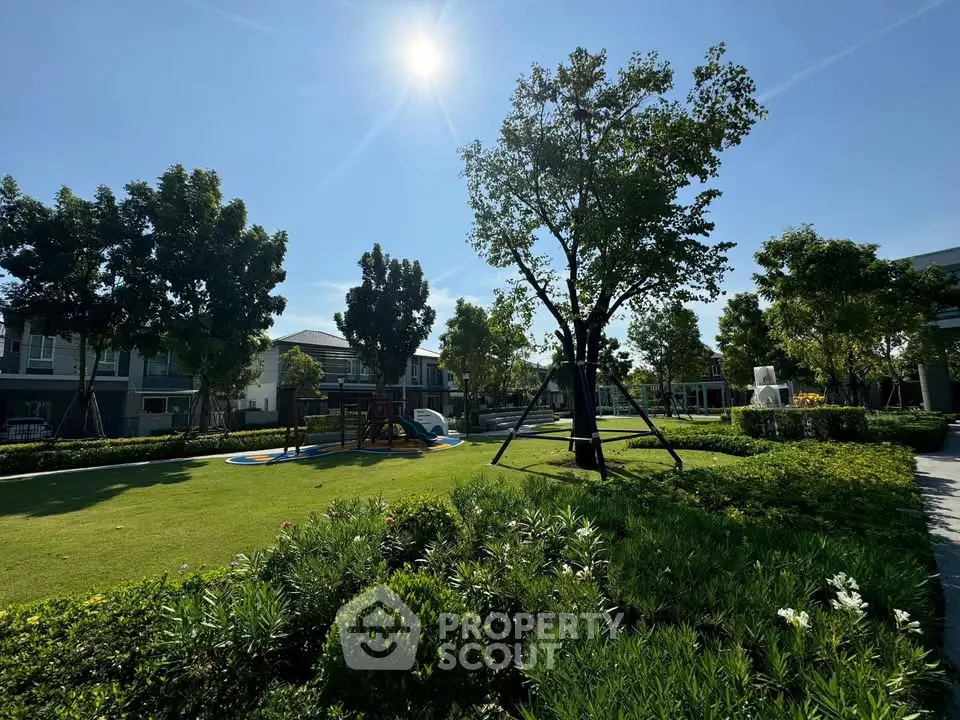 Beautiful landscaped garden with lush greenery and playground in a residential community.