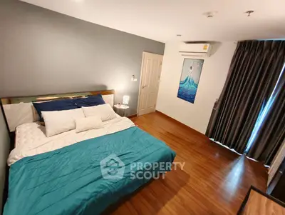 Spacious bedroom with wooden flooring and modern decor in a stylish apartment.