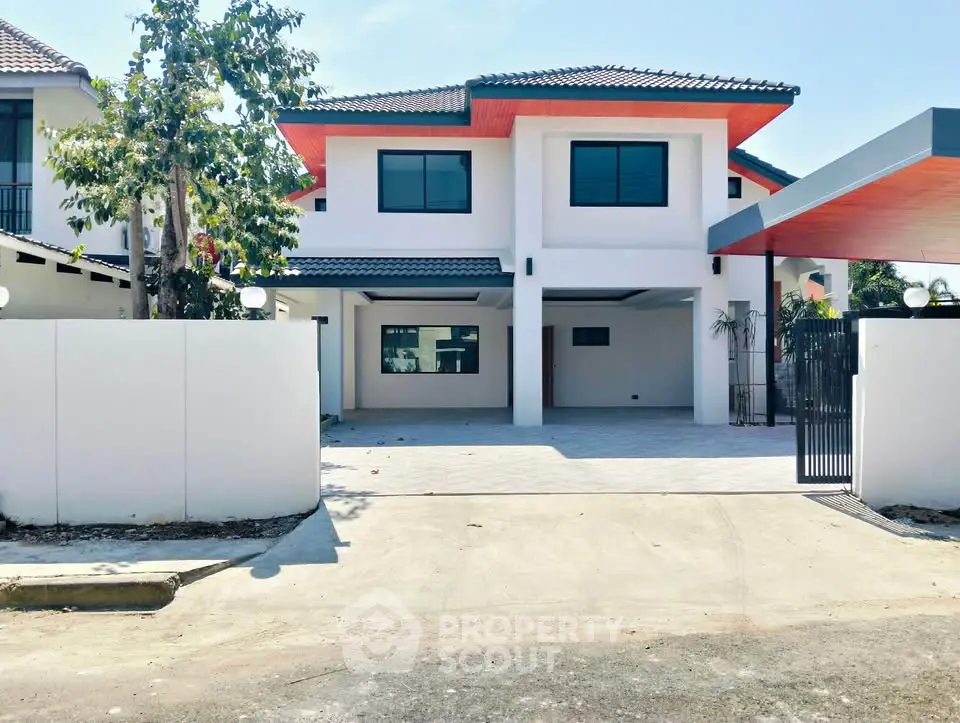 Modern two-story house with spacious driveway and sleek exterior design.