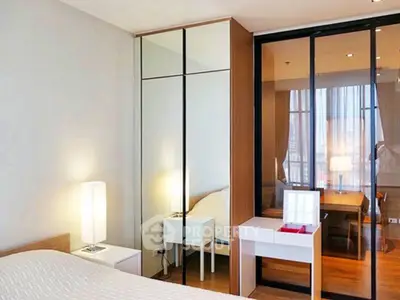 Modern bedroom with mirrored wardrobe and elegant lighting in a stylish apartment.