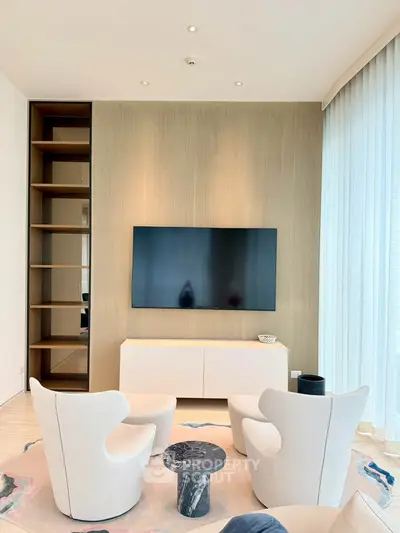 Luxurious modern living room with elegant furniture and large TV, perfect for relaxation and entertainment.