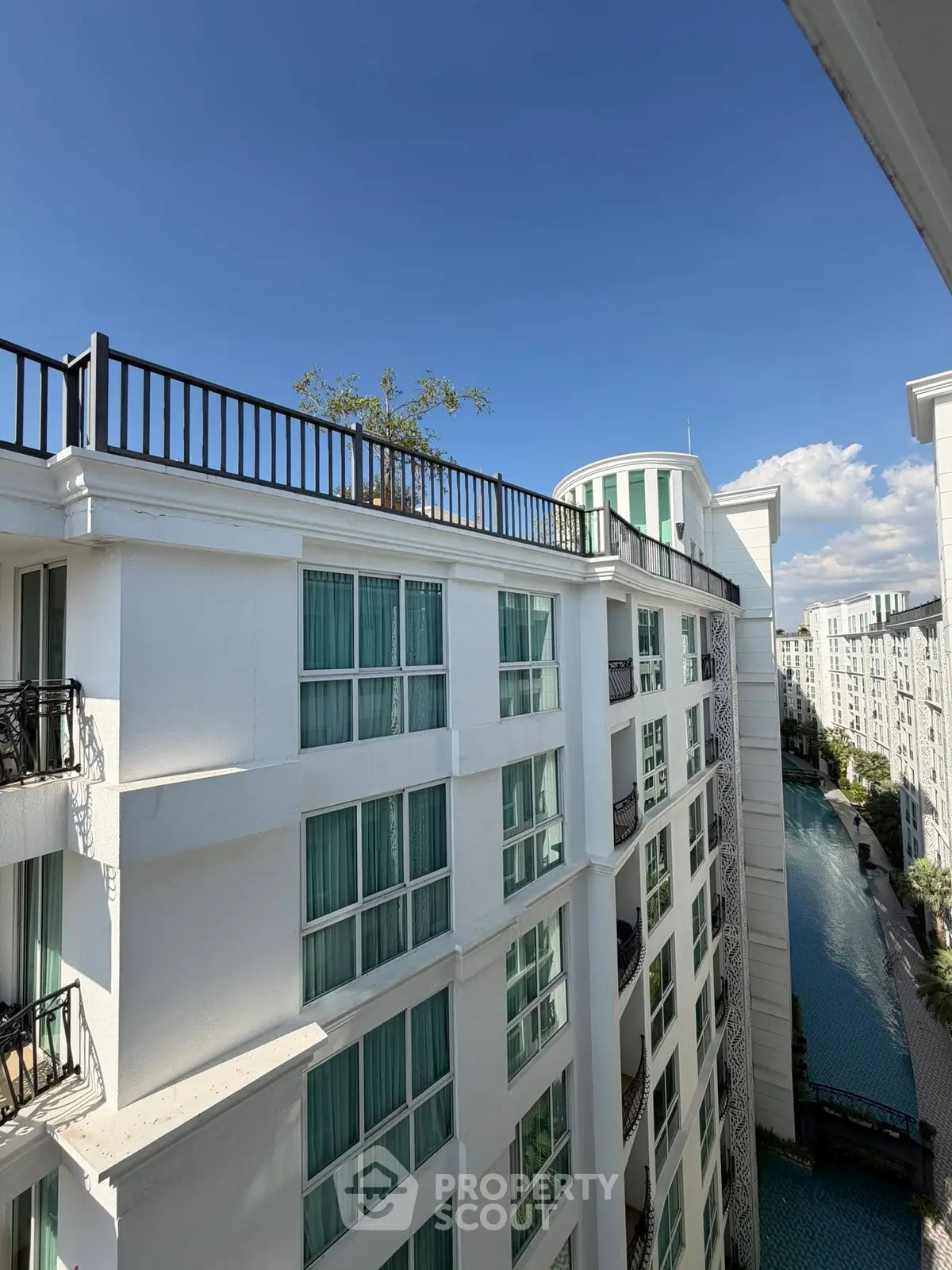 Stunning view of modern white apartment building with blue sky backdrop.