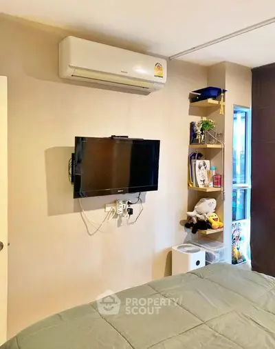 Cozy bedroom with wall-mounted TV and air conditioning unit