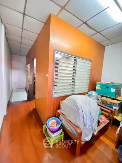 Cozy interior space with wooden walls and ceiling, featuring a small seating area and storage boxes.