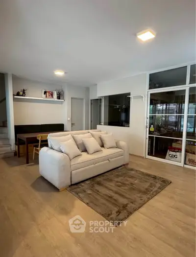 Spacious living room with modern decor and cozy seating area, perfect for relaxation and entertainment.