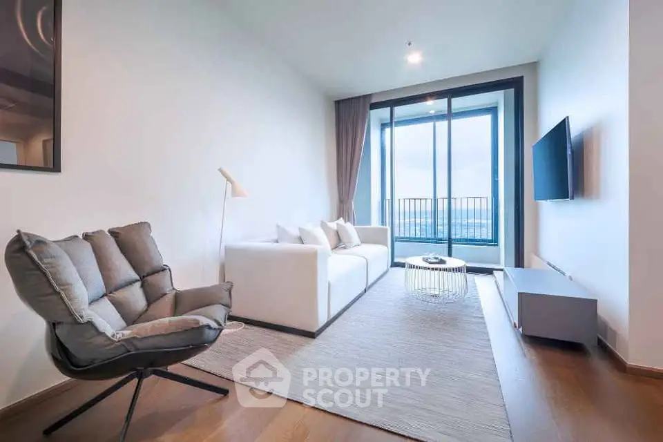Modern living room with stylish furniture and large window offering stunning city views.