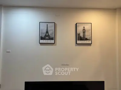 Modern living room with stylish wall art featuring Paris and London landmarks.