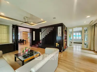 Spacious modern living room with elegant wooden flooring and stylish staircase