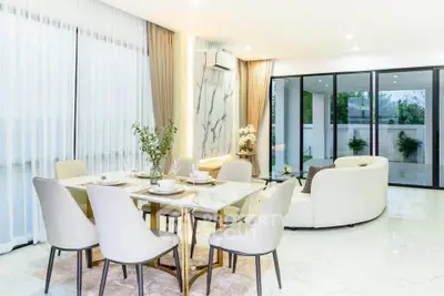 Luxurious open-plan living and dining area with elegant decor and large windows.