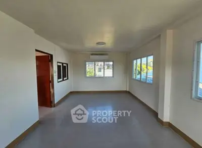 Spacious empty room with large windows and air conditioning unit