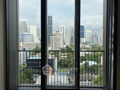 Stunning cityscape view from modern apartment balcony with floor-to-ceiling windows.
