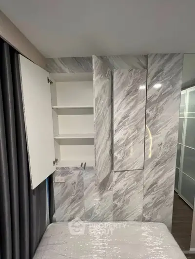 Modern bedroom with sleek marble wall design and built-in storage