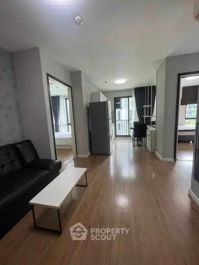 Modern apartment interior with open layout, featuring a cozy living area and a view of the balcony.