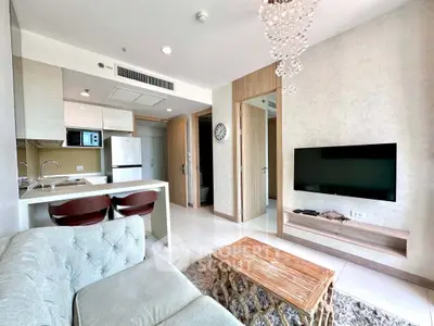 Modern living room with open kitchen, stylish decor, and cozy seating in a contemporary apartment.