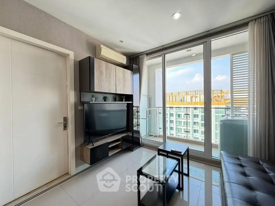 Modern living room with balcony and city view, featuring sleek furniture and natural light.