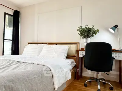 Modern bedroom with cozy bed and stylish desk, perfect for work and relaxation.