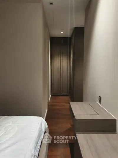 Sleek modern bedroom with wooden flooring and built-in wardrobe