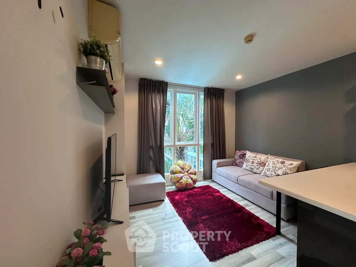 Modern living room with cozy sofa, vibrant rug, and large window view