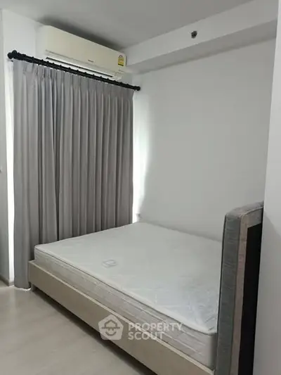 Minimalist bedroom with air conditioning and natural light