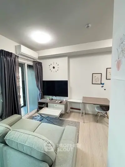 Modern living room with stylish decor and balcony access, featuring a cozy sofa and wall-mounted TV.