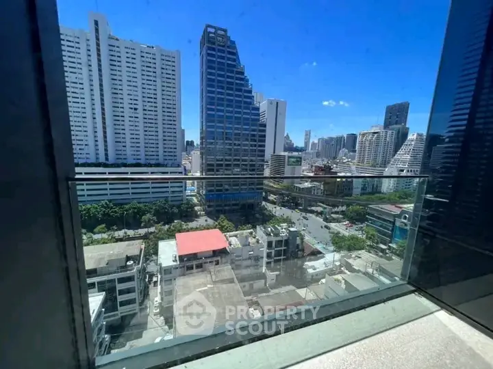 Stunning cityscape view from a modern balcony with glass railing, perfect for urban living.
