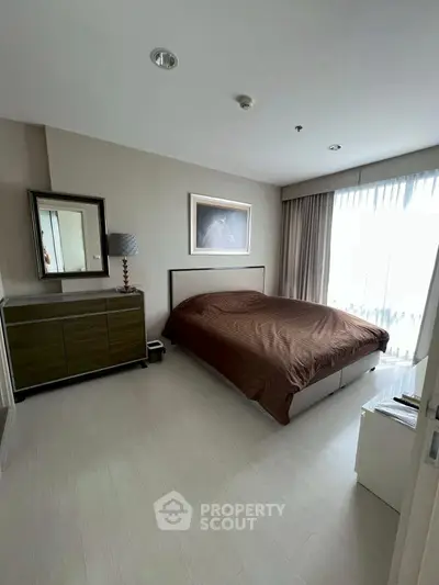 Elegant bedroom with modern decor and large window for natural light.