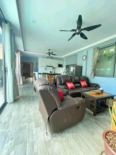 Spacious living room with modern furniture and open kitchen layout, perfect for family gatherings.