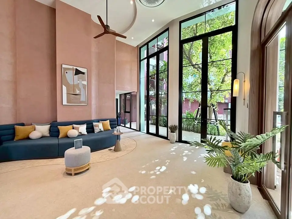 Spacious modern living room with high ceilings and large windows overlooking greenery.