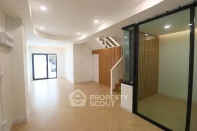 Spacious modern living room with wooden flooring and glass partition
