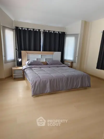 Spacious bedroom with modern decor and large windows
