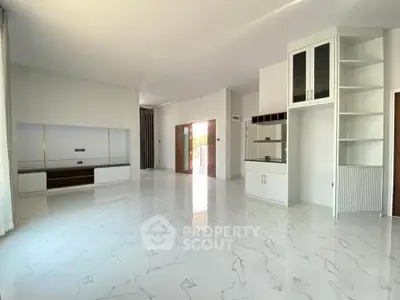 Spacious modern living room with sleek white marble flooring and built-in storage.
