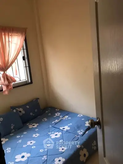 Cozy small bedroom with floral bedding and natural light