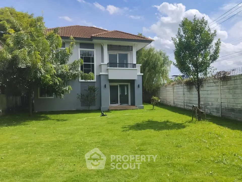 Charming two-story house with lush green garden and spacious lawn, perfect for family living.