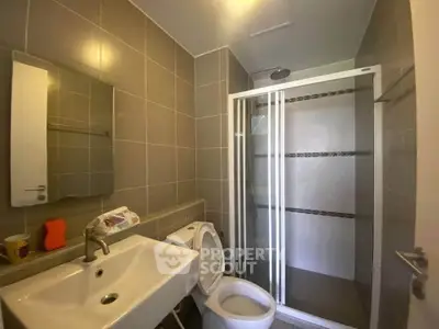 Modern bathroom with sleek shower and stylish sink in contemporary apartment.