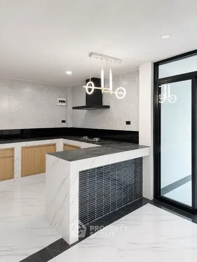 Modern kitchen with sleek marble countertops and stylish lighting in a contemporary home.