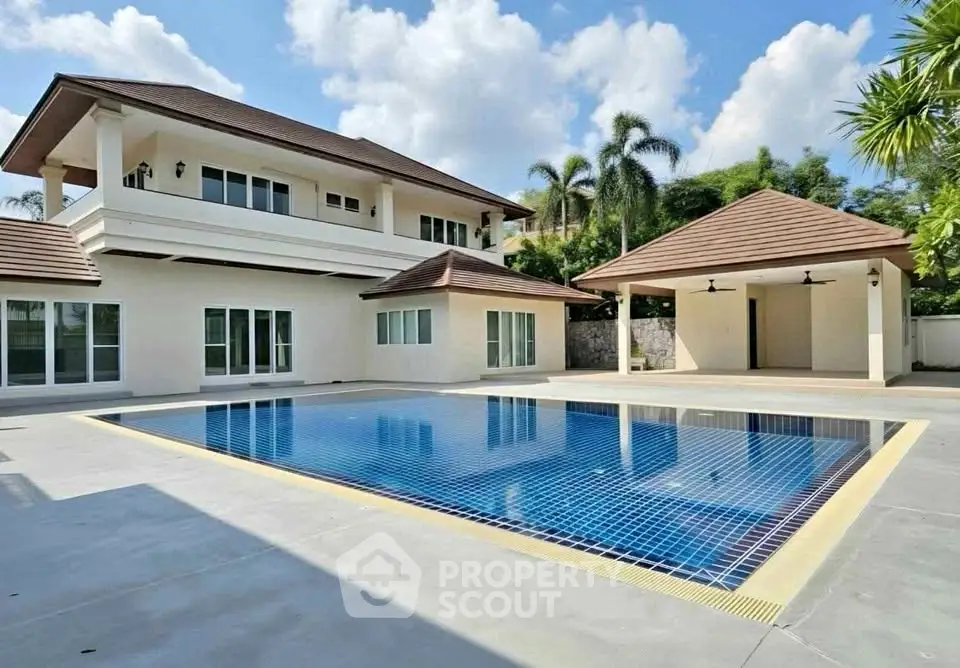 Luxurious villa with private pool and spacious outdoor area under clear blue skies.