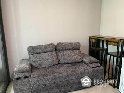 Modern living room with stylish grey sofa and bar stools