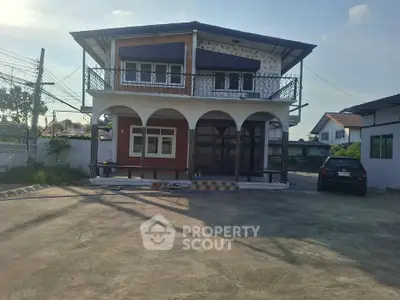 Charming two-story house with spacious driveway and balcony in a serene neighborhood.