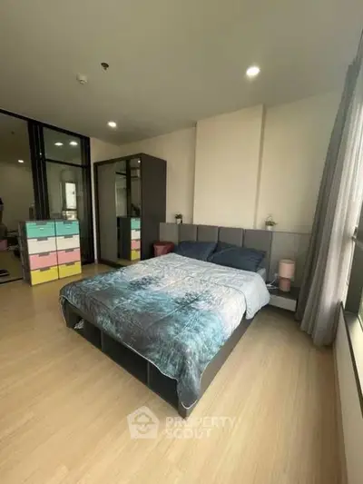 Spacious bedroom with modern decor and large window for natural light