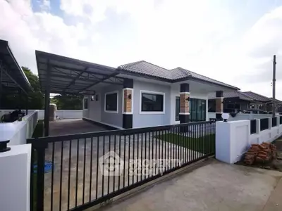 Modern single-story house with gated driveway and sleek exterior design.