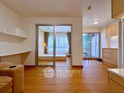 Spacious modern apartment with open layout and wooden flooring, featuring a cozy living area and bright bedroom.