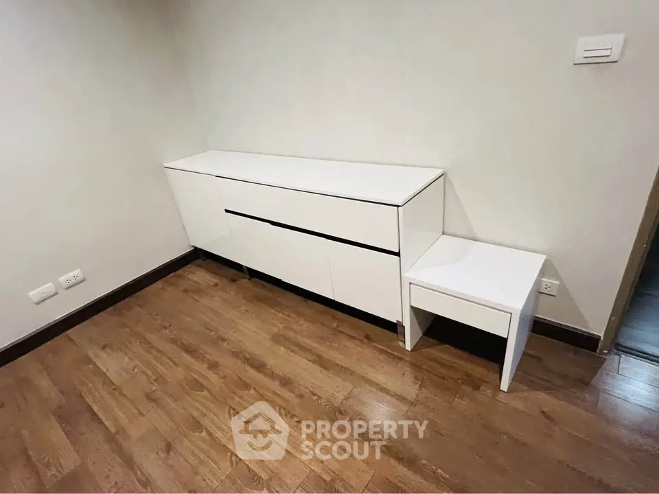 Modern minimalist room with sleek white furniture and wooden flooring