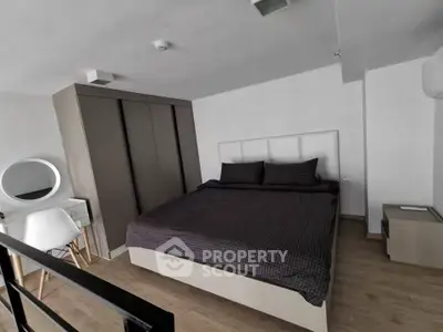 Modern bedroom with sleek design, featuring a large bed, built-in wardrobe, and stylish vanity area.