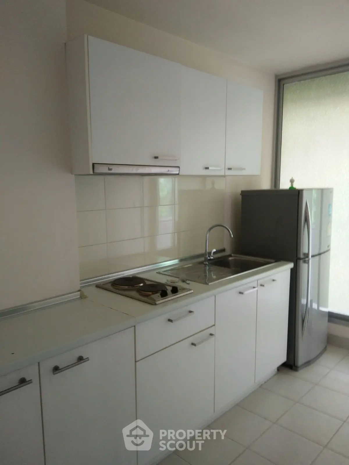 Modern kitchen with sleek white cabinetry and stainless steel appliances.